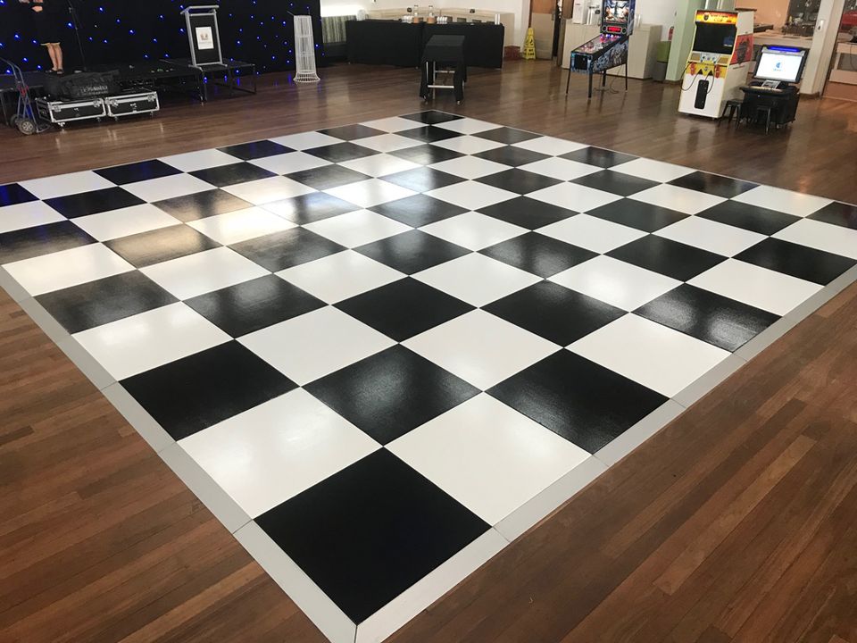 Black and white checkered dance floor in a timber-floored hall