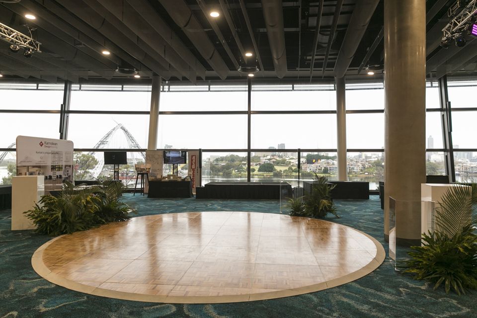 Round timber-look dance floor in a function room with water views