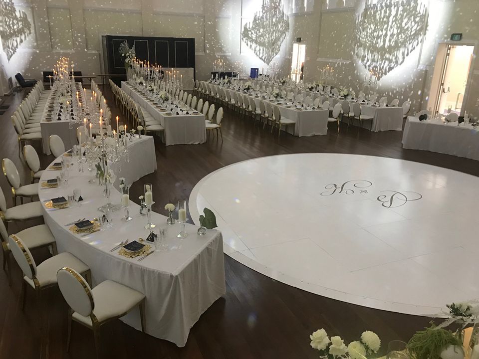 Round white dance floor surrounded by reception tables
