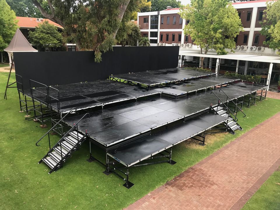 Tiered black staging set up on a lawn