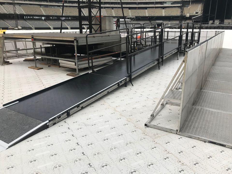 Staging platform with a handrailed ramp inside a stadium