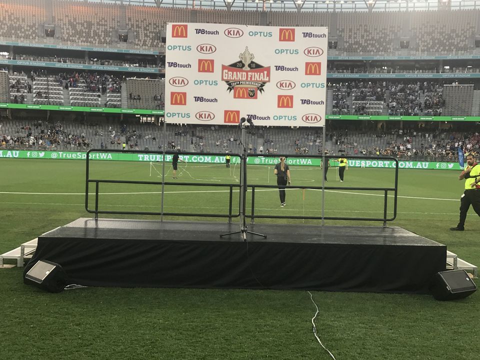 Rolling stage positioned on a sports ground in front of a crowd