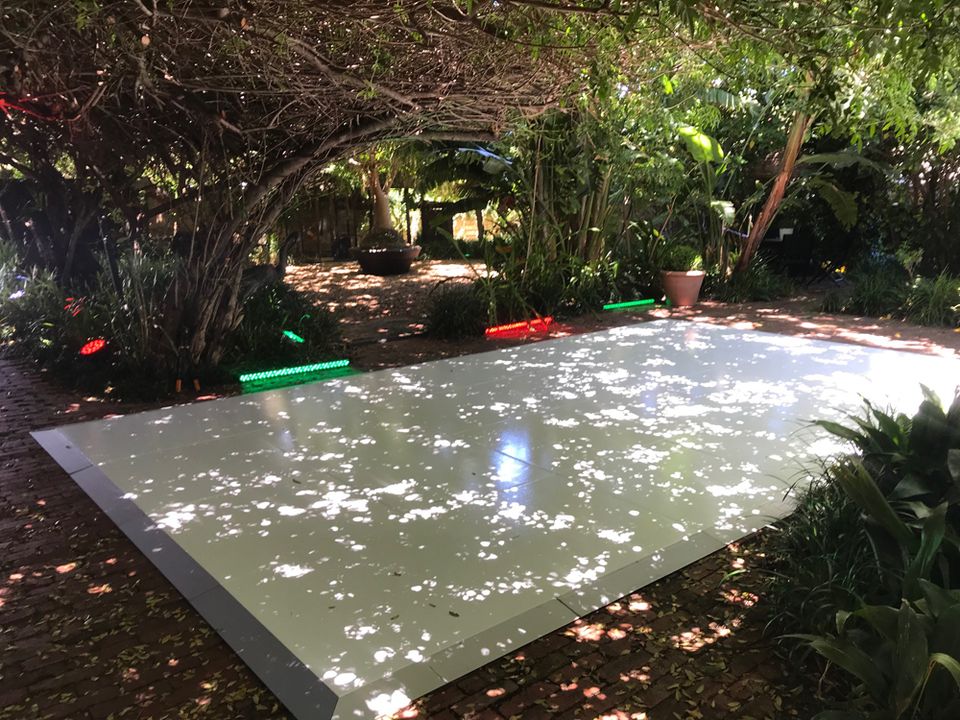 White dance floor laid in a leafy garden
