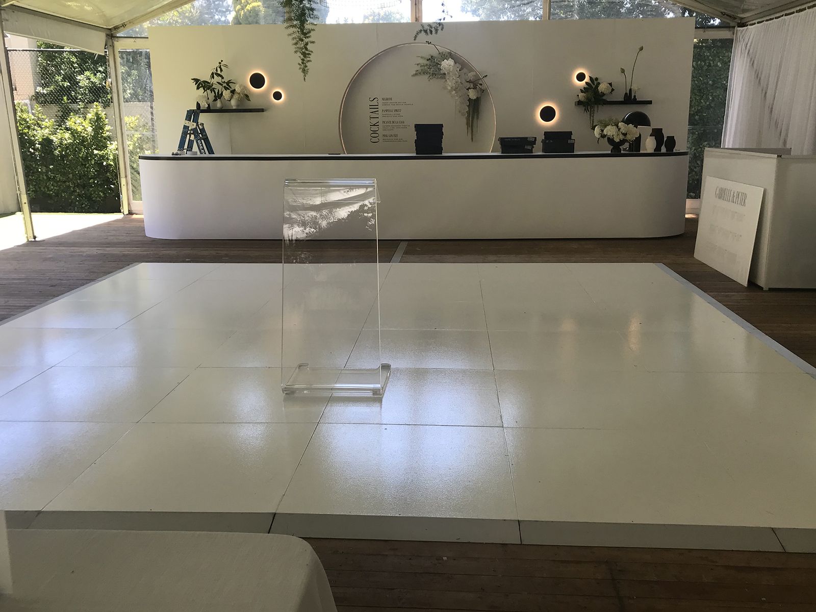 White gloss dance floor inside a marquee in front of a DJ booth