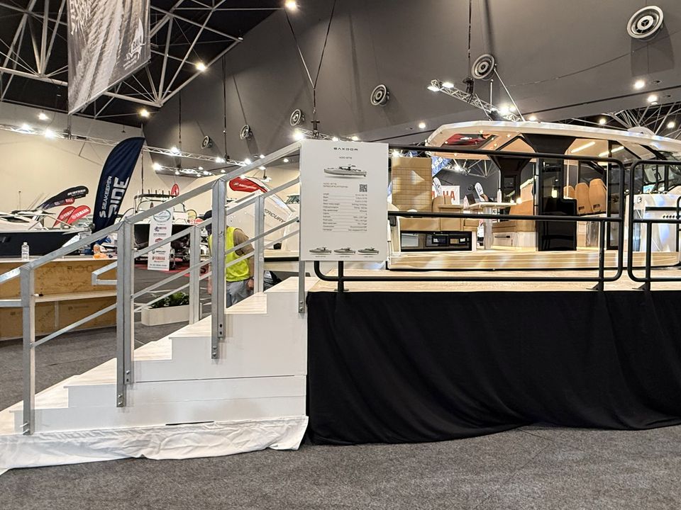 Raised display stage with black skirting and handrails in an exhibition hall
