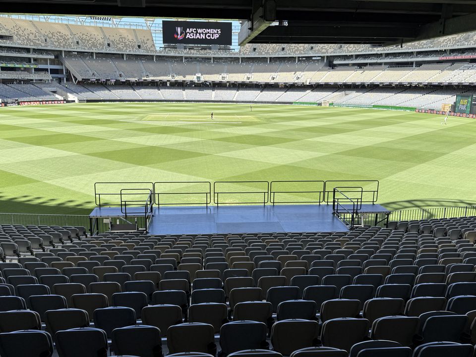 Raised, railed viewing platform built across rows of stadium seating, facing the field