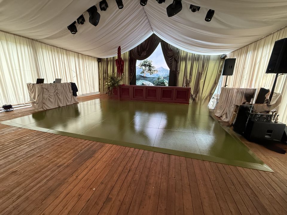 Olive-green gloss dance floor on a timber deck inside a draped marquee