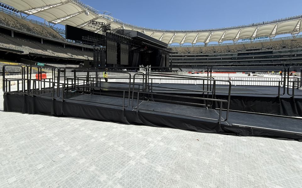 Railed viewing platform with an access ramp on a stadium surface